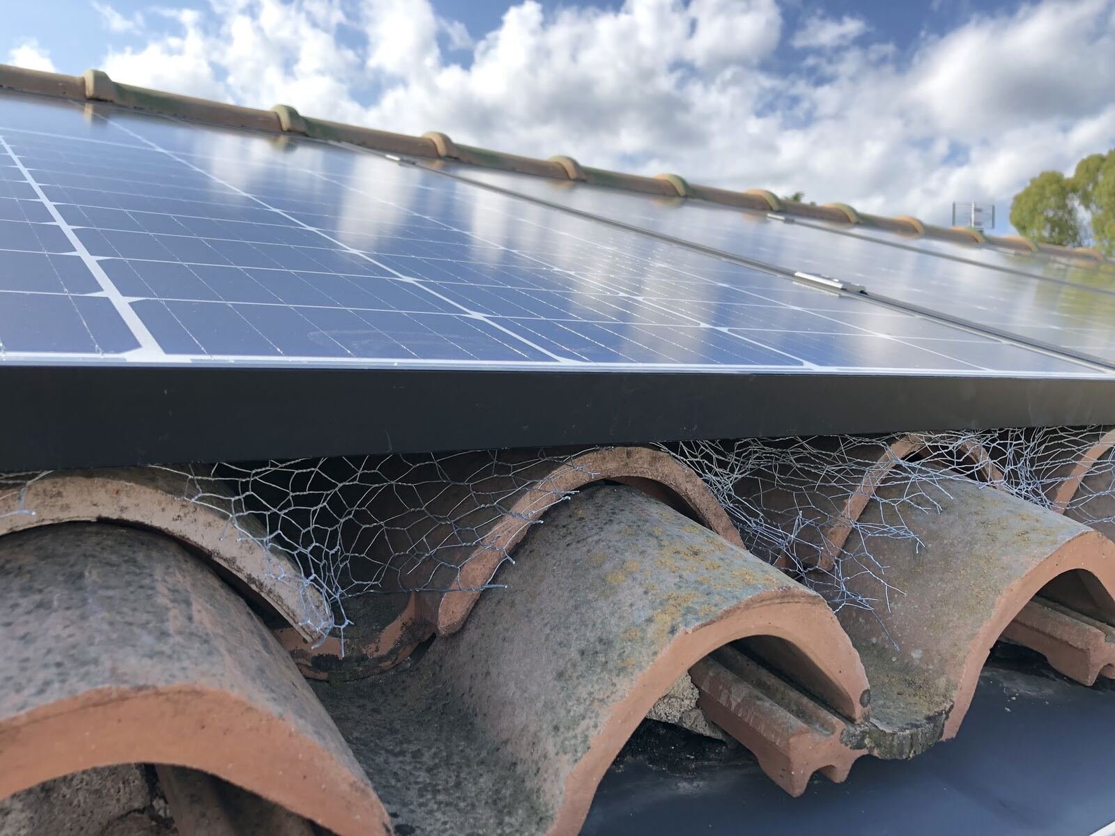 Detalle del montaje de un panel solar sobre tejado de teja